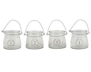 Et foto af adventsstager i glas med tal