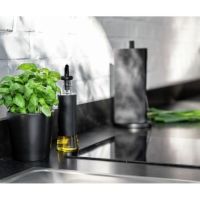 Potteskjuler i sort med krydderurter på køkkenbordet