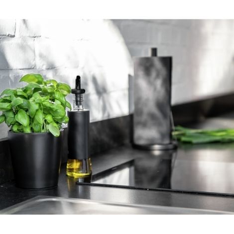 Potteskjuler i sort med krydderurter på køkkenbordet