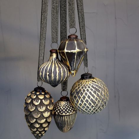 forskellige julekugler ophængt med kogler i guld og antique kul farve