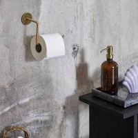 Messing toiletrulleholder på væg med toiletpapir