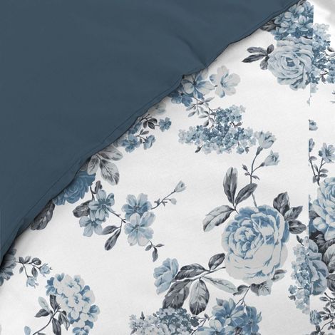 Nærbillede af mønstret på hvidt sengetøj med blomster