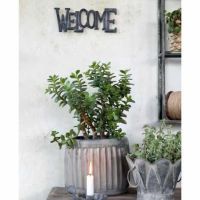 Metal skilt welcome ophængt på væggen med skruer