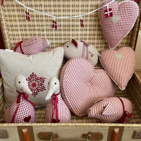 Dørstopper dyr i stof gris stillet op som julepynt med andre dyr og puder