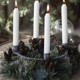 Adventslysestage med spyd her sat i en krans med gran og kogler dekoreret fint