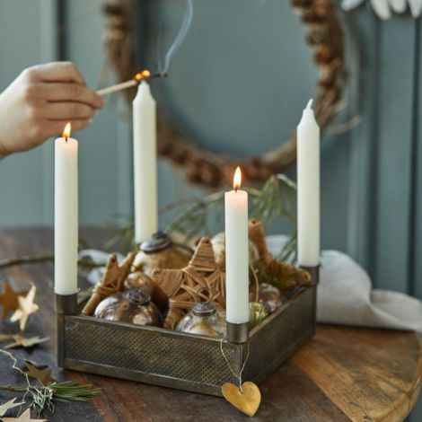 Advents lysestage firkantet i messing på bordet med kronelys og pynt