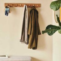 Lang knagerække i egetræ 100 cm. med 8 messing kroge ophængt på væg i entre