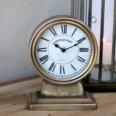 Stående ur i messing her på en kommode til pynt