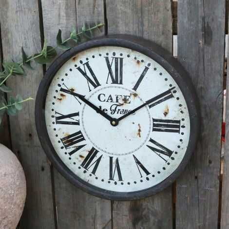 Stort ur med metalramme hængt op på væg