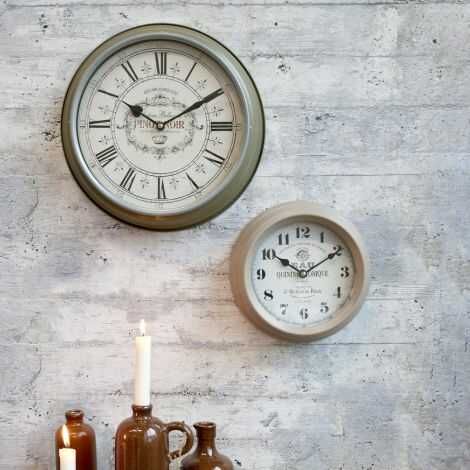 Vægur med tal hængt op på væg ved siden af et andet ur