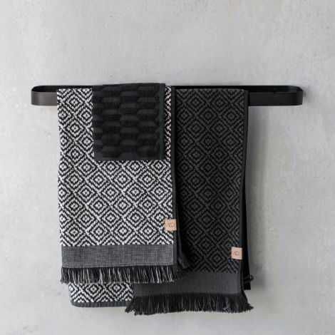 Tyrkiske håndklæder sort grå hænger på håndklædestangen på badeværelset