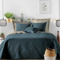 Flere blå pudebetræk lagt på innerpuder som pyntepuder oven på sengetæppe i soveværelse