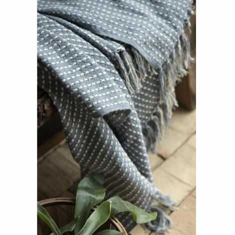 Støv blå plaid der ligger på bænken i entreen