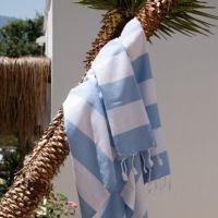 Tynde strandhåndklæder hammam hænger på en gren på stranden