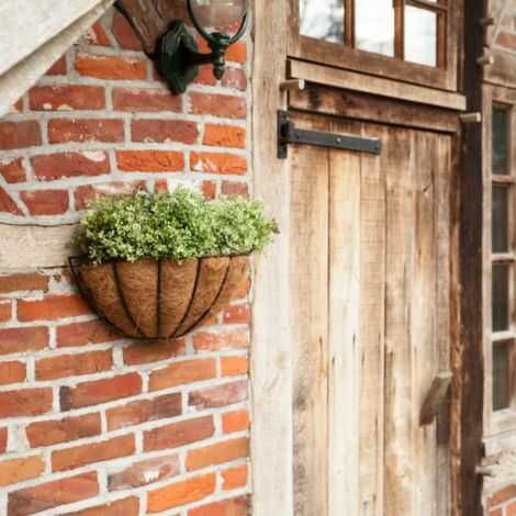 Blomsterkurv til væg ophægt på muren ved hoveddøren med planter
