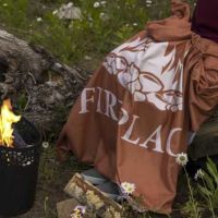 Polyester plaid på træstub ved grill stedet i haven