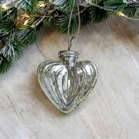 Sølv julepynt hjerte liggende med lidt gran til pynt til jul