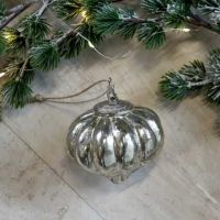 Sølv juledråbe liggende med lidt gran til pynt til jul