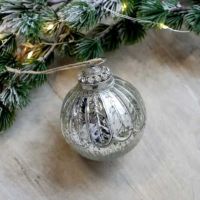 Julekugler sølv liggende med lidt gran til pynt til jul