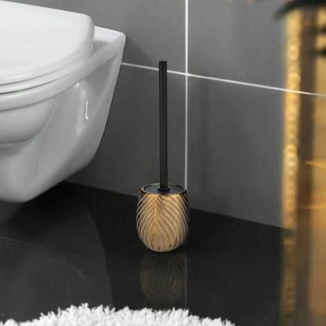 Keramik wc børste i smukt guld design står på badeværelset ved siden af toilettet