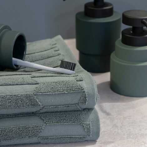 Mørkegrønne håndklæder pine green på bordet på badeværelset
