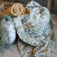 Quiltet vattæppe med blomster og blade mønster udfoldet så mønsteret ses