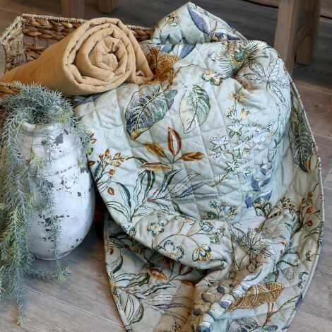 Quiltet vattæppe med blomster og blade mønster udfoldet så mønsteret ses