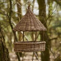 Pileflet foderhus ophængt i et træ i haven til mad til fuglene