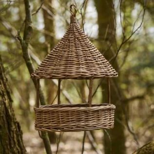 Pileflet foderhus ophængt i et træ i haven til mad til fuglene