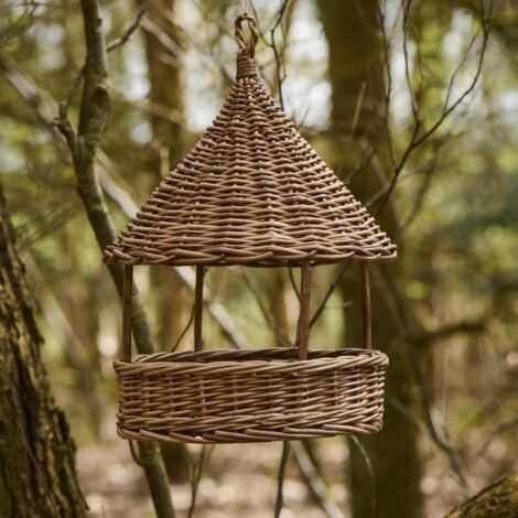 Pileflet foderhus ophængt i et træ i haven til mad til fuglene