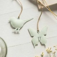 Søde grønne fugle til pynt ligger som dekoration på et bord og skaber forårsstemning