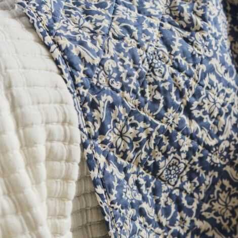 Vattæppe blå med råhvidt mønster udfoldet over en stol