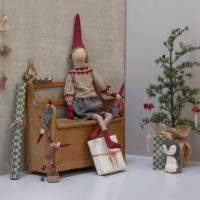 Nisse Maileg pige str 6 der sidder på en bænk dekorativt med andre maileg nisser